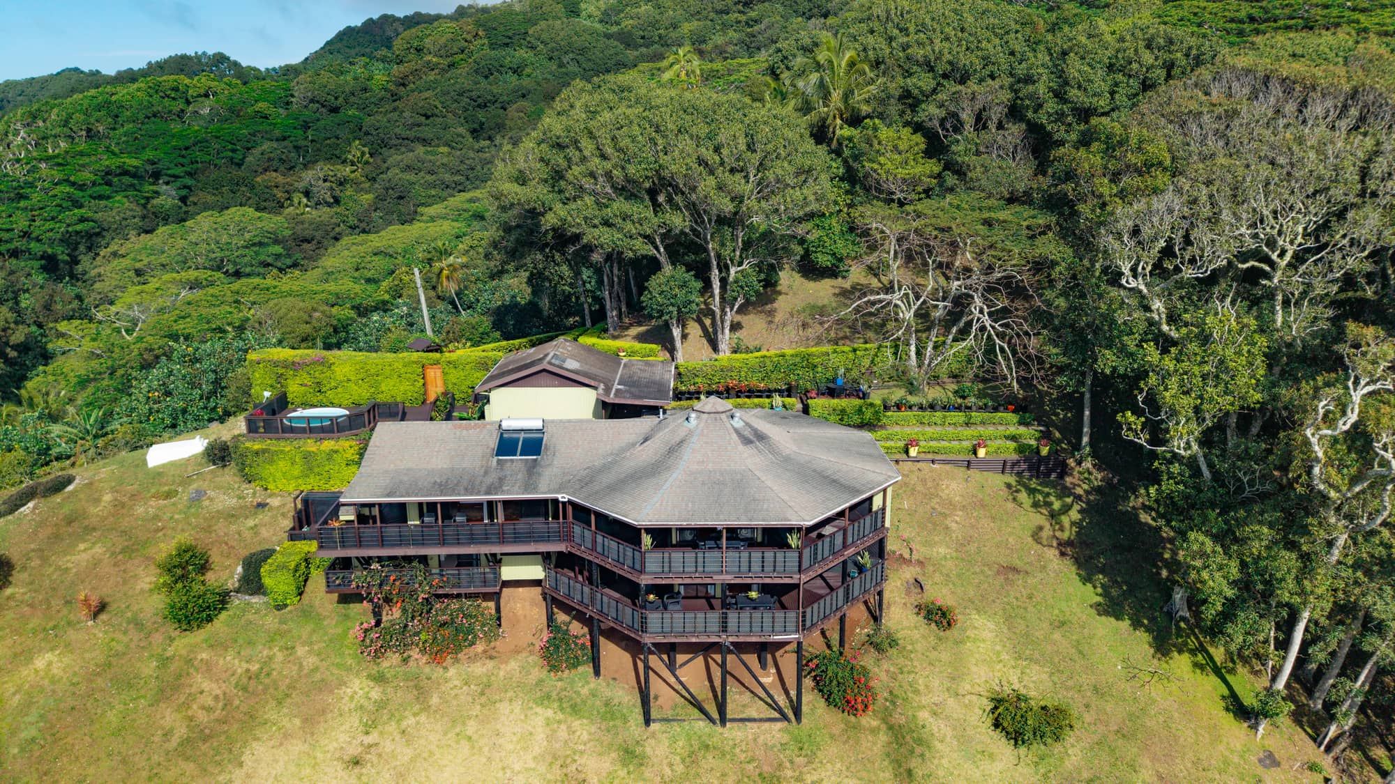 Aerial view of the octagonal home with wraparound decks and plunge pool on a private hillside, Muri, Rarotonga, Cook Islands
